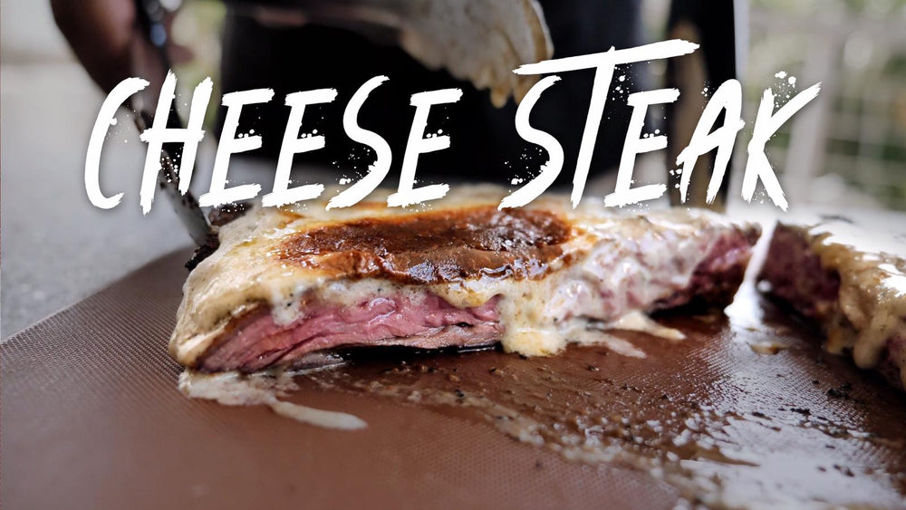 Skirt steak cut open on a board, covered in melted blue cheese cream