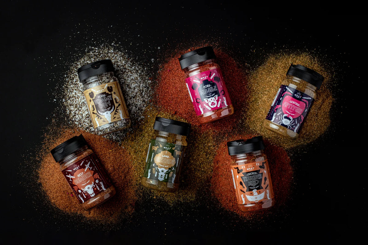 Six Meat Lab rubs photographed with their seasonings on a dark surface