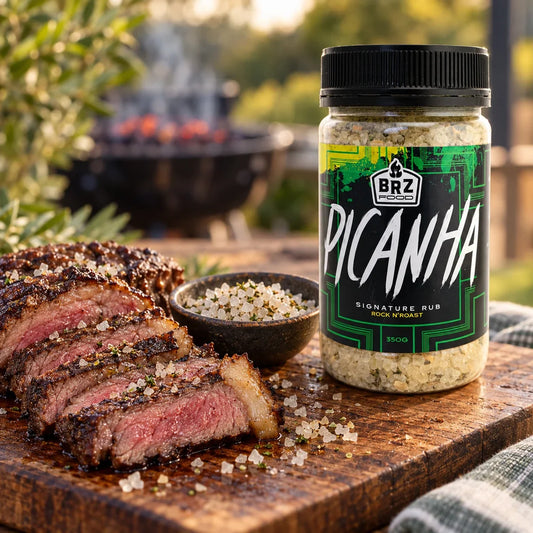 The pairing. Styled scene of the official Picanha rock salt seasoning jar beside sliced rump cap on a barbecue board - Secondary view
